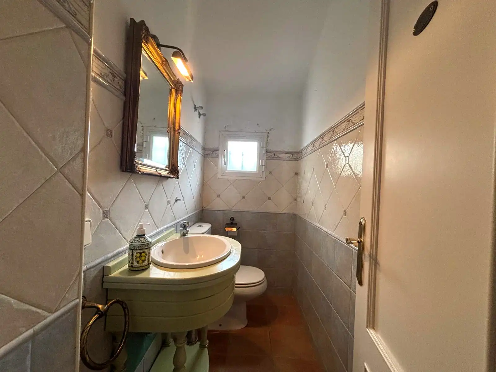 Aseo de cortesía con lavabo y ventana exterior.