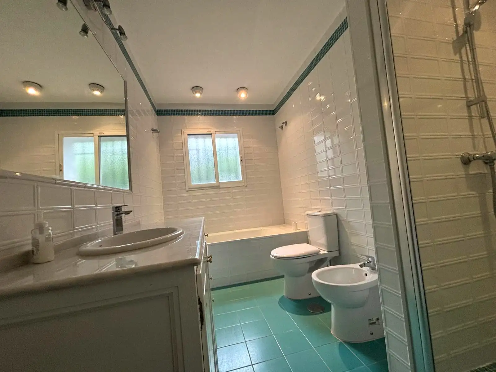 Baño completo con bañera, ducha, bidet y lavabo en tonos blanco y azul en Brisas II, Manilva.