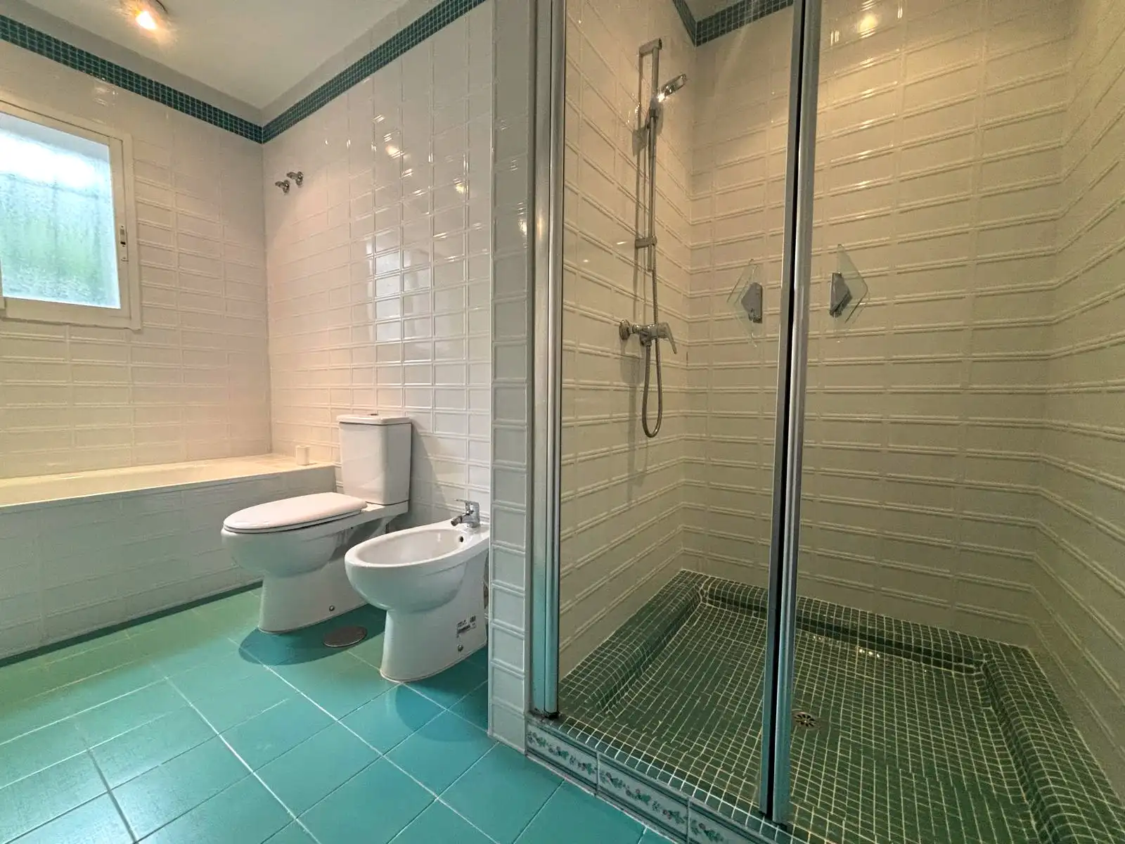 Baño completo con bañera, ducha junto a ventana exterior y mueble lavabo en Brisas II, Manilva.