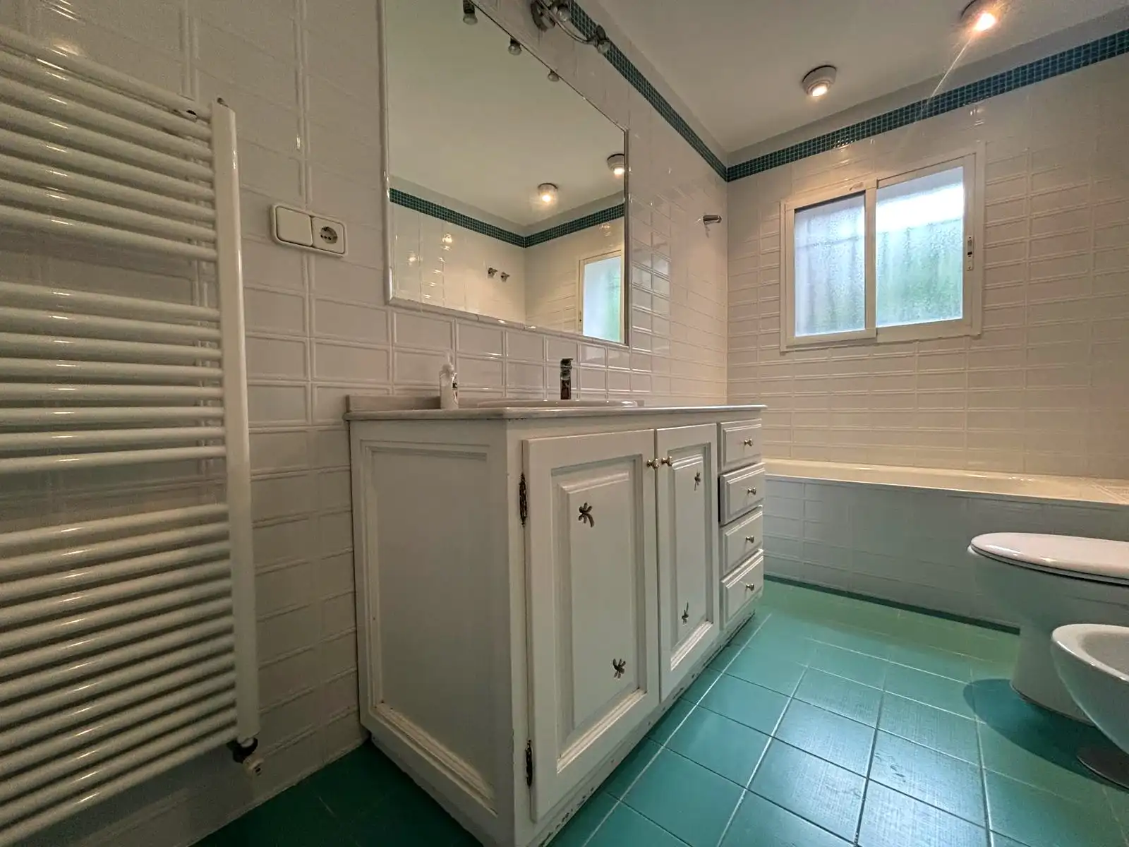 Baño completo con lavabo, bañera encastrada y detalle de azulejo azul en Brisas II, Manilva.