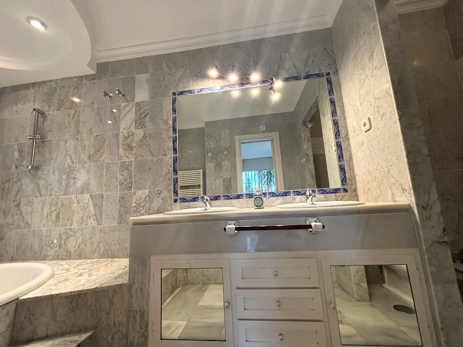 Baño principal con doble lavabo, bañera encastrada y ducha en Brisas II, Manilva.