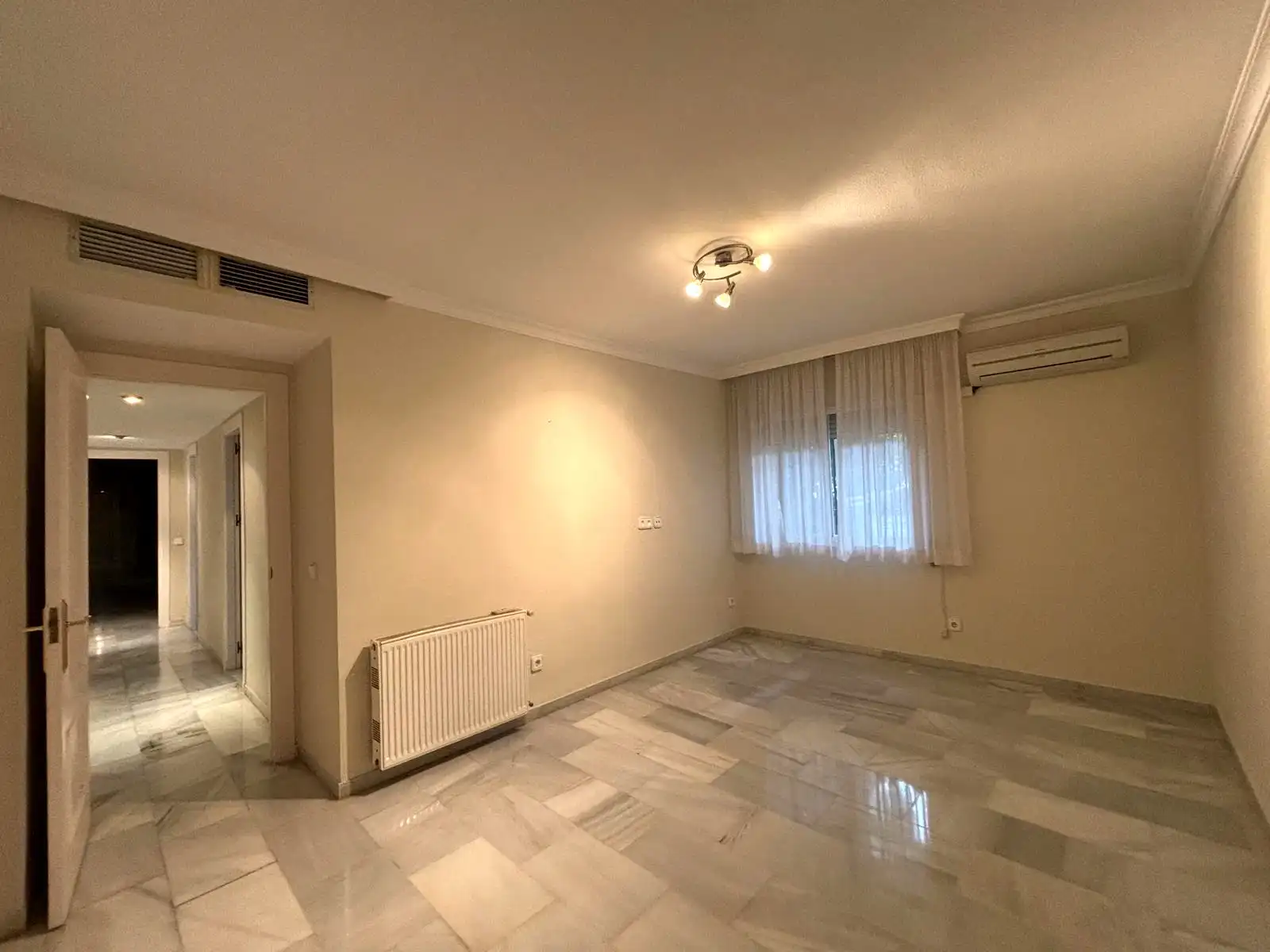 Dormitorio con ventana exterior, aire acondicionado y suelos de mármol en Brisas II, Manilva.