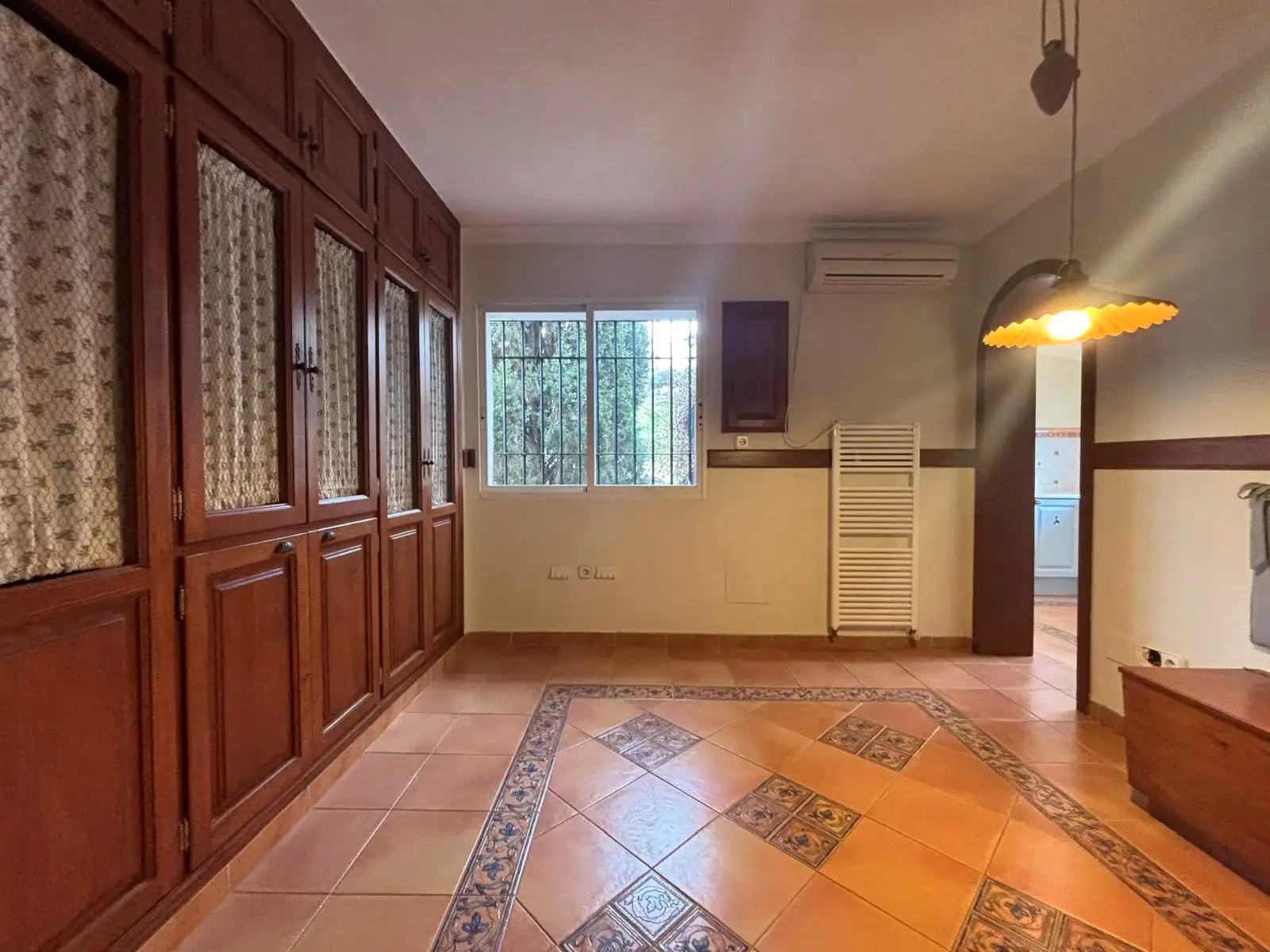 Zona office junto a la cocina con armarios de madera, banco en esquina y paso directo a la cocina.