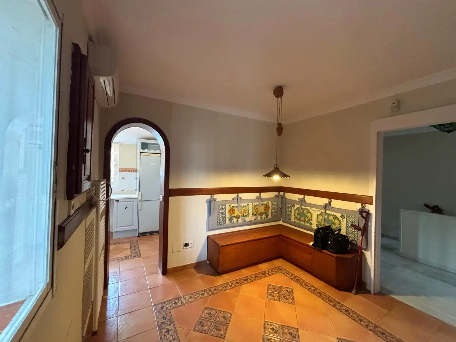 Zona office junto a la cocina con armarios de madera a medida y pavimento cerámico.